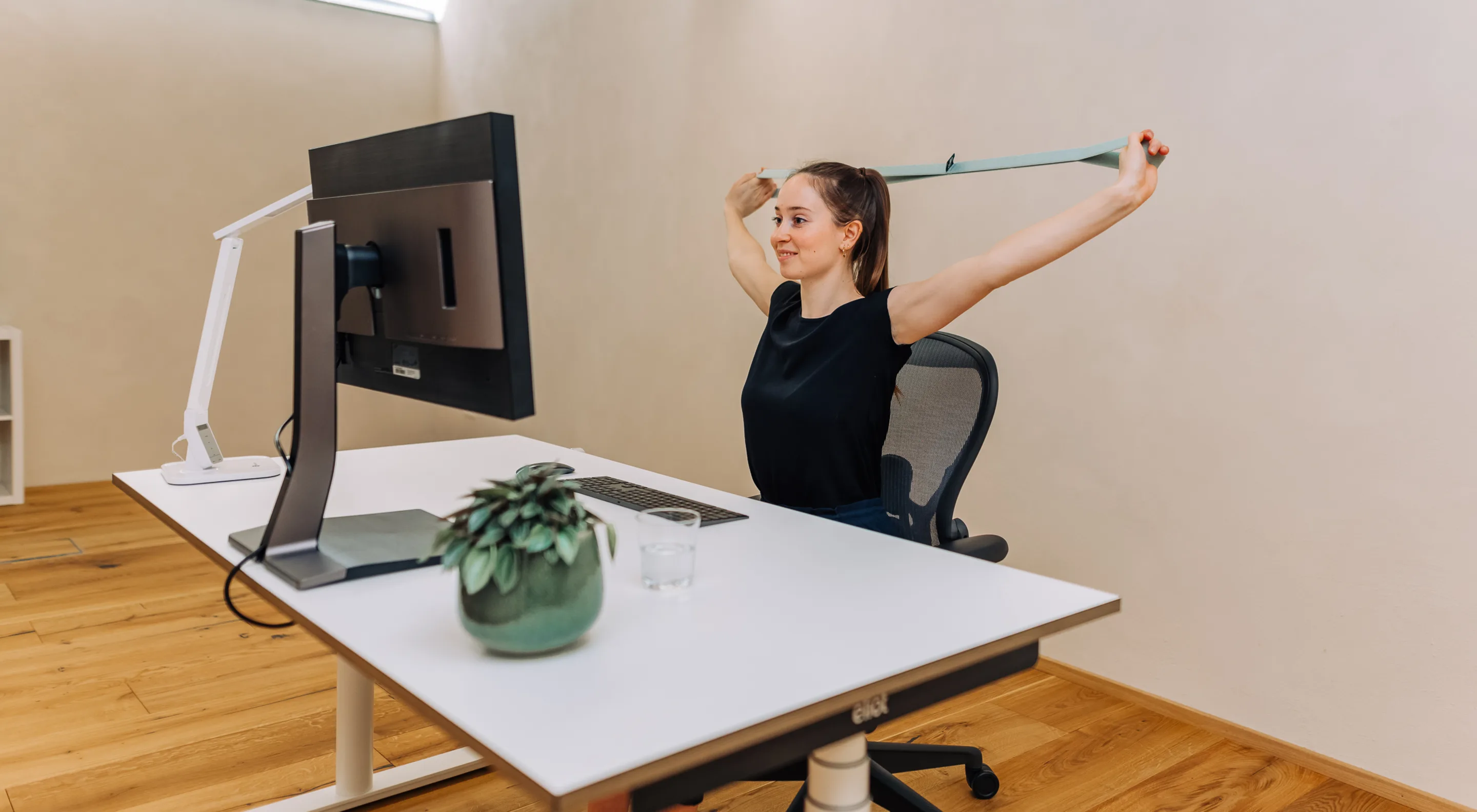 Worker adjusting ergonomic chair at office desk